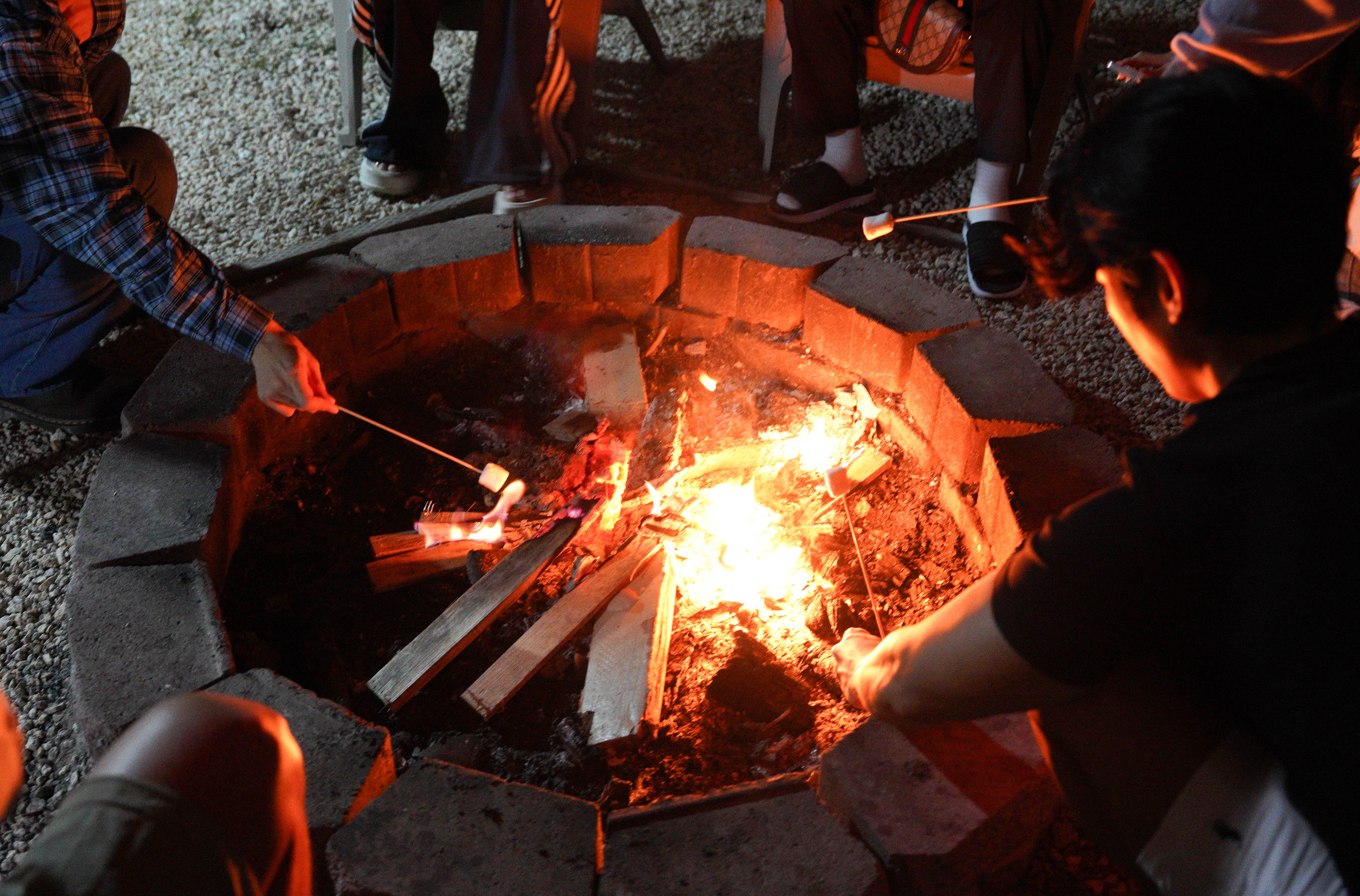 괌 별빛투어에서 모닥불 주위에 모여 앉아 담소를 나누는 여행자들